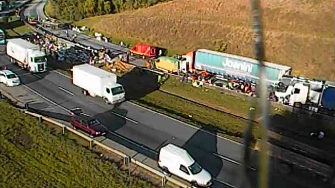 Colisão entre quatro caminhões e dois ônibus deixa 20 pessoas feridas na BR-381 em Oliveira