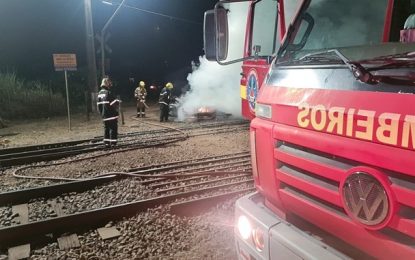Bombeiros combatem incêndio em veículo próximo a linha férrea